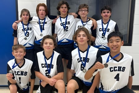 Estudiantes de la County Central High School posan en sus uniformes de baloncesto frente a una pared azul.