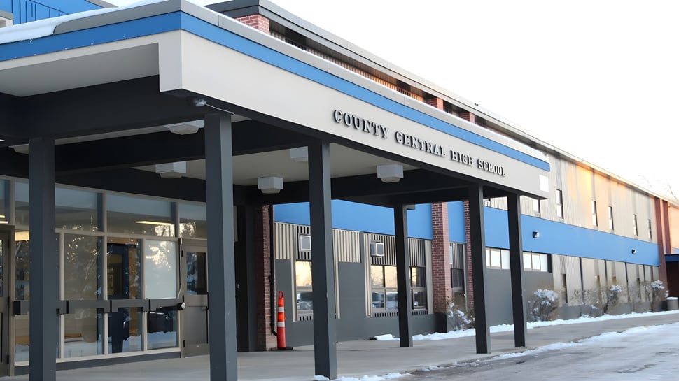 El moderno edificio de varios pisos de la County Central High School está cubierto de nieve invernal con una entrada techada.