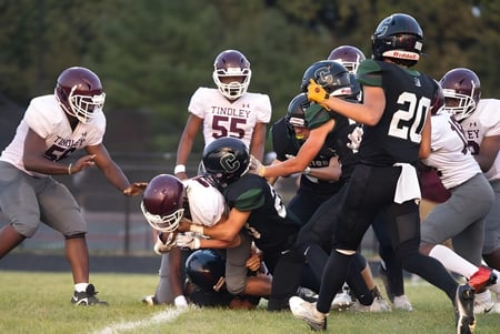 Estudiantes de la Covenant Christian High School juegan al fútbol en el campo deportivo y luchan por el balón.