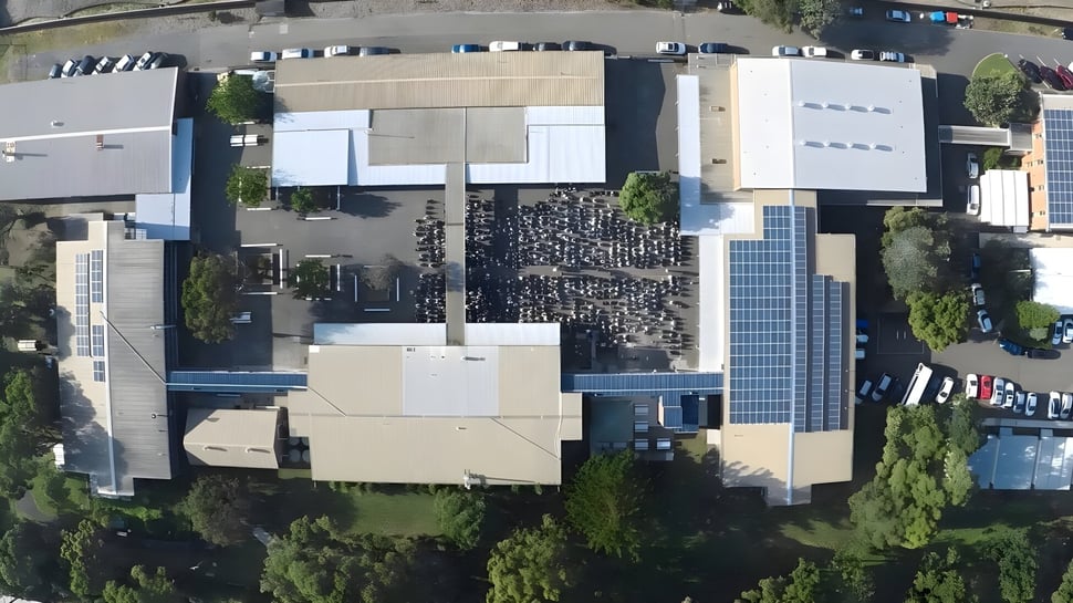 El edificio de varios pisos de la Cronulla High School está rodeado de árboles y otros edificios.