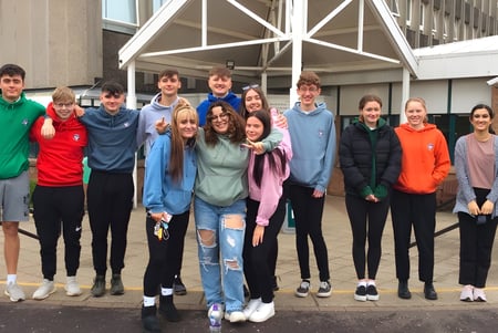 Un grupo de estudiantes está frente al edificio distintivo de la Currie Community High School.