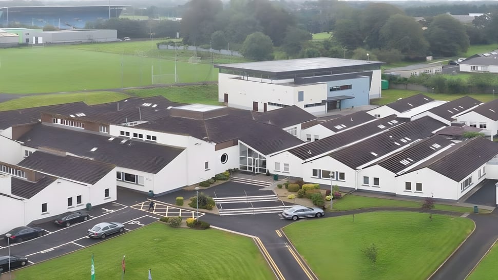 El campo deportivo y los edificios circundantes en el campus del Davitt College están rodeados de un paisaje verde.