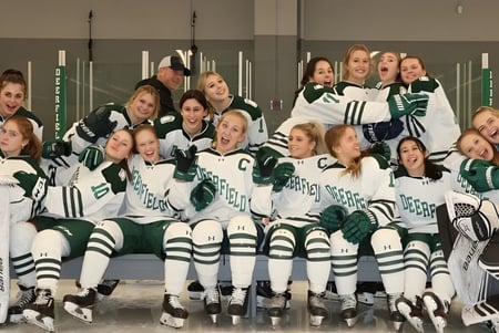 Un grupo de jóvenes alumnas en uniforme de hockey posan en una instalación deportiva en el campus de la Deerfield Academy.