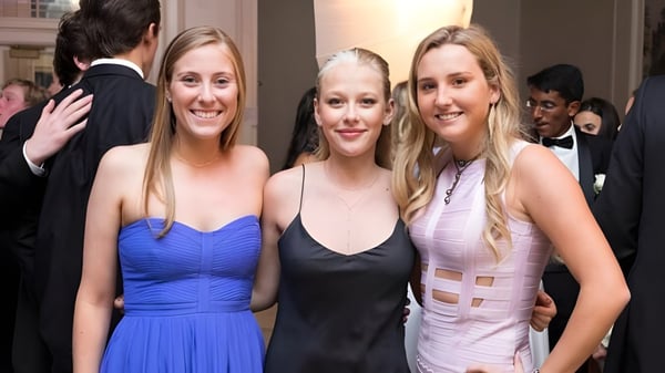 Tres alumnas de la Deerfield Academy posan juntas en un evento en la alfombra roja.