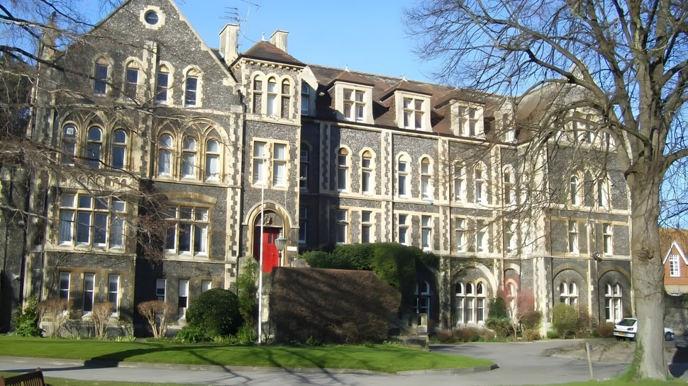 El edificio gótico del Dover College está rodeado de árboles y áreas verdes.