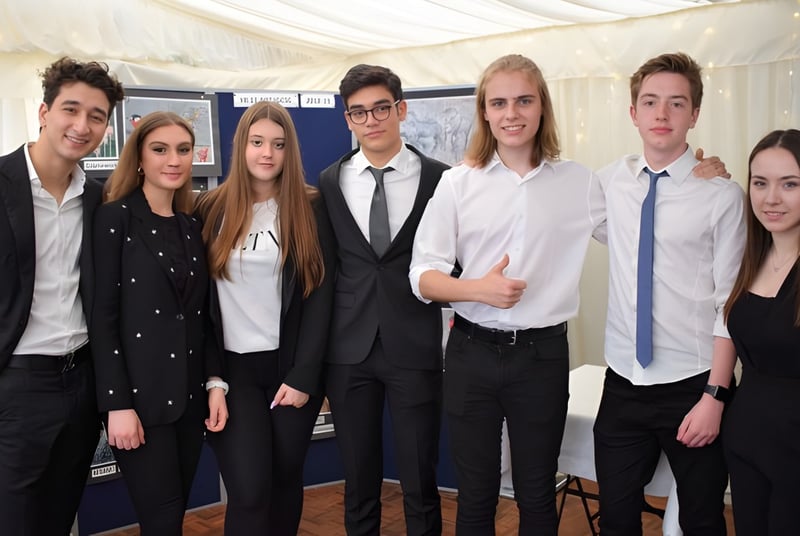 Un grupo de estudiantes del D'Overbroeck's College posan con ropa formal frente a una carpa blanca.