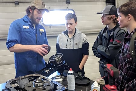 Estudiantes de la Dr. Elliott School trabajan juntos en un objeto mecánico en el taller.
