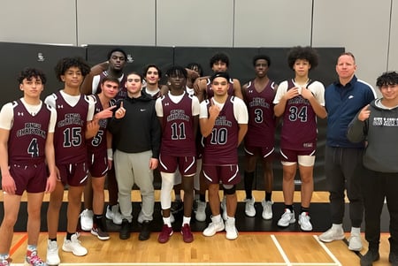 Un grupo de jóvenes estudiantes de baloncesto está en uniforme en la cancha de baloncesto de la Dr. Frank J. Hayden Secondary School.