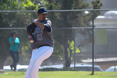 Un jugador de béisbol en uniforme azul oscuro está en el campo del Duarte Unified School District.