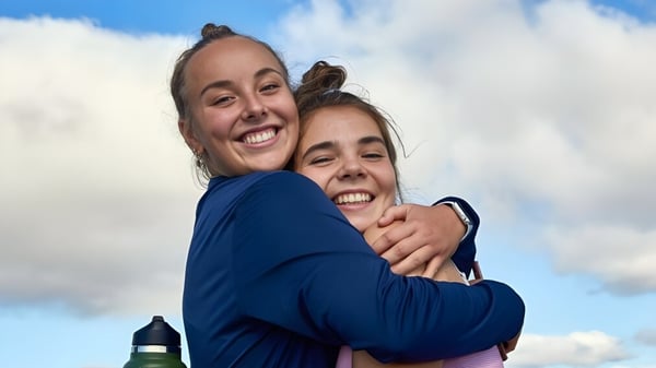 Dos personas sonrientes se abrazan frente al cielo nublado en el campus de la Dublin School.