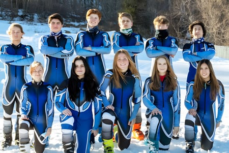 Un grupo de estudiantes de la Earl of March Secondary School está en trajes de esquí azules y negros en un bosque nevado.