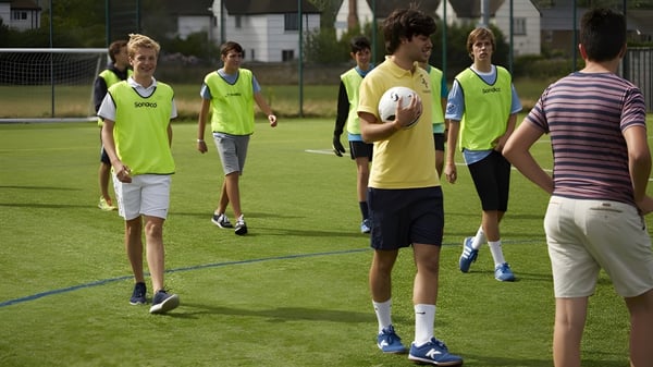 Un grupo de estudiantes de la Earlscliffe School se reúne en el campo deportivo para una actividad recreativa.