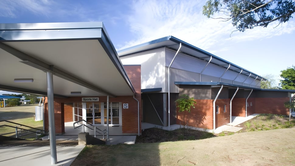 El moderno edificio de ladrillo de una sola planta con entrada cubierta y área de césped en el campus del Earnshaw State College.