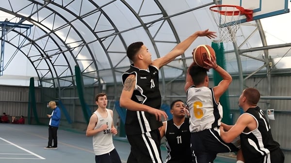 Los estudiantes juegan baloncesto en el gimnasio del East Sussex College Eastbourne.