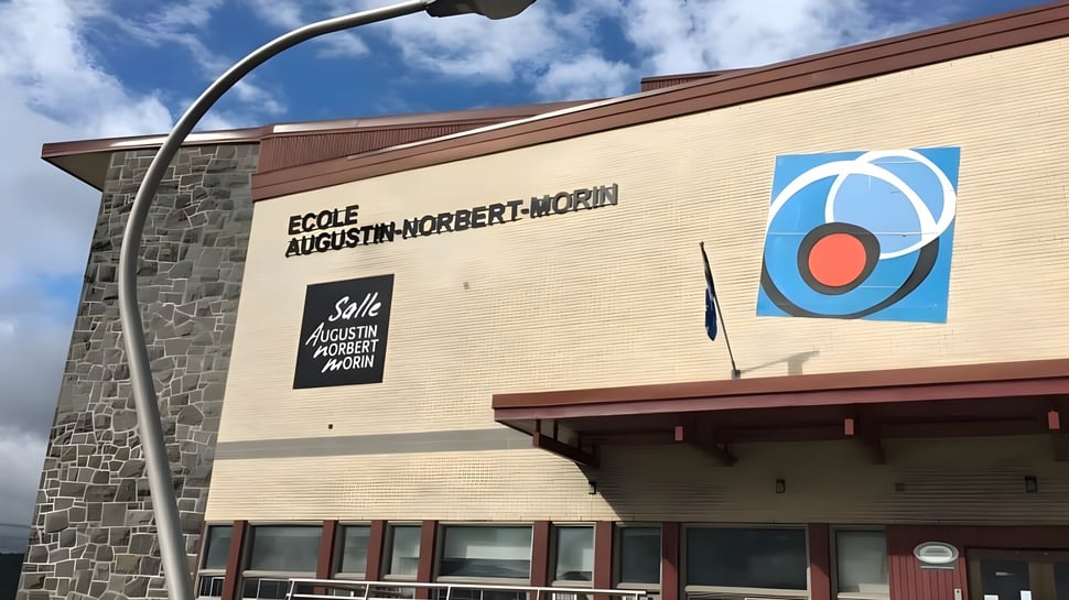 El edificio escolar de la École Secondaire Augustin-Norbert-Morin muestra una fachada de piedra y ladrillo con un gran letrero del nombre de la escuela.