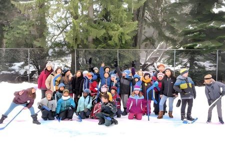 Un grupo de estudiantes de la École des Sentiers-Alpins está en el área exterior nevada bajo los árboles.