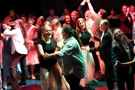 Un grupo de estudiantes de la École Salish Secondary School celebra juntos en el escenario.