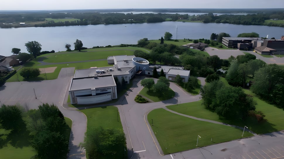 Toma aérea del complejo vacacional con áreas verdes y edificios en el terreno de la École secondaire publique L'Héritage.