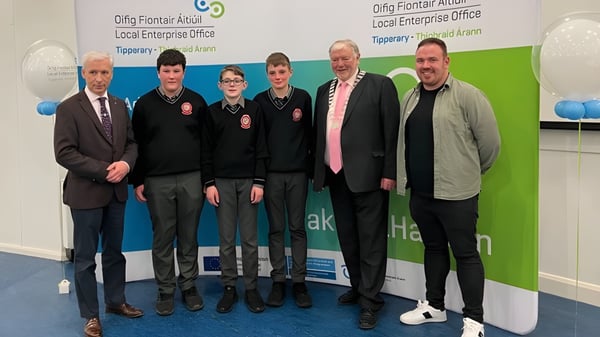 Estudiantes de la Edmund Rice Secondary School están frente a un fondo con el letrero Clonmel Enterprise Office.