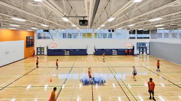 La sala de baloncesto de la Elsie MacGill Secondary School con una gran cancha y equipos deportivos.