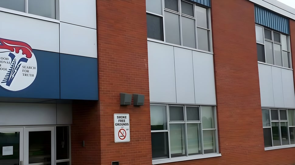 El moderno edificio de varios pisos de Elwood Regional High con fachada de ladrillo rojo y grandes ventanas.