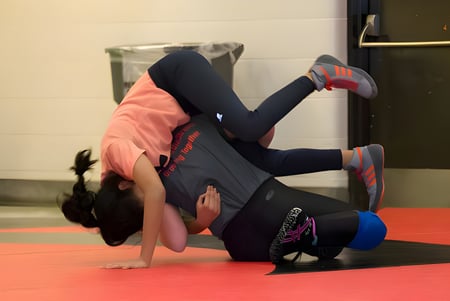 Una estudiante del Emery Collegiate Institute hace un pino sobre una alfombra roja en el gimnasio.