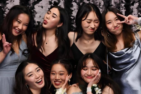 Un grupo de jóvenes mujeres en ropa formal posan frente a una cortina brillante en el campus de la Epsom Girls Grammar School.