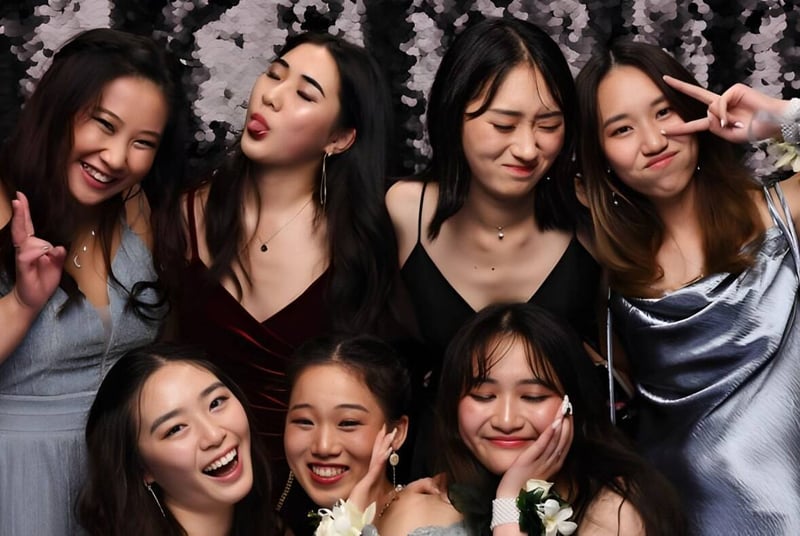 Un grupo de jóvenes mujeres en ropa formal posan frente a una cortina brillante en el campus de la Epsom Girls Grammar School.