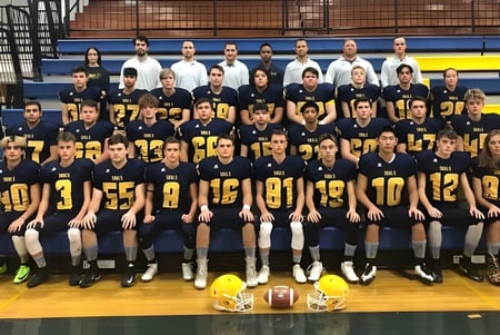 Estudiantes de la Evan Hardy Collegiate se reúnen en un gimnasio con equipo deportivo.
