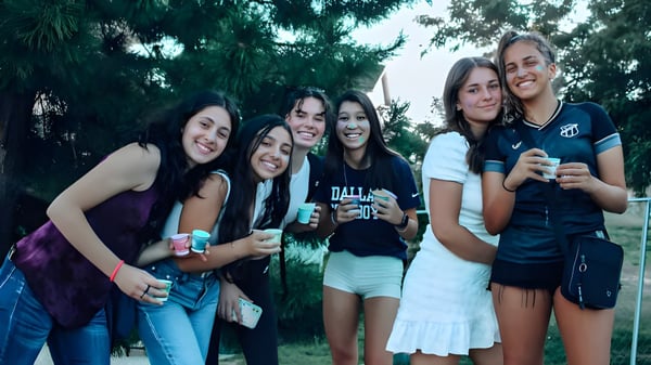 Un grupo de alumnas sonrientes se agrupan en el área verde al aire libre del F-1 No Choice Programm USA.
