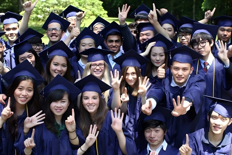 Un grupo de graduados de la Fairfax Christian School está al aire libre en togas y birretes azules.