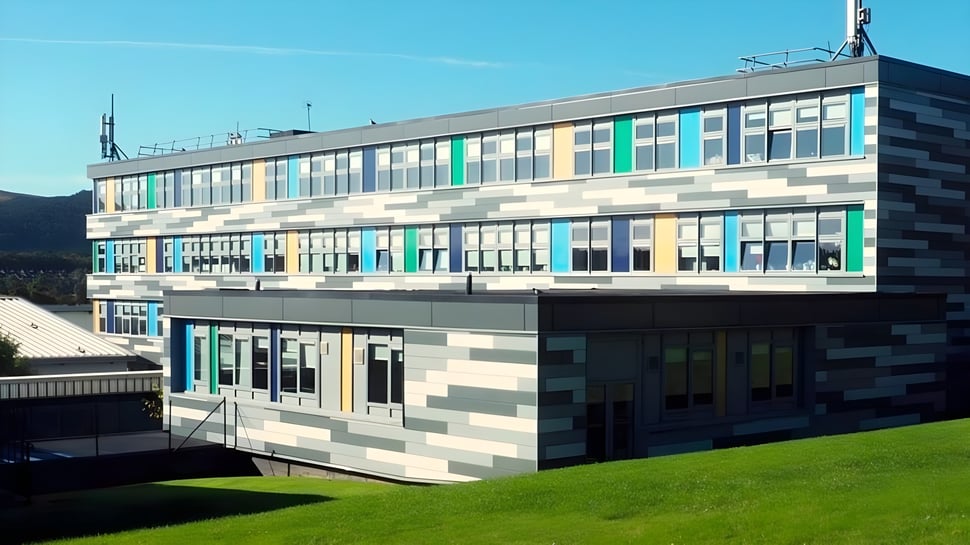 El moderno edificio de varios pisos con fachada geométrica colorida en el terreno de la Firrhill High School.
