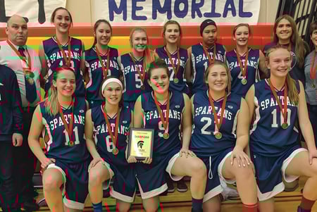 El equipo de baloncesto de la Forest Lawn High School posa junto con su trofeo después de una victoria.