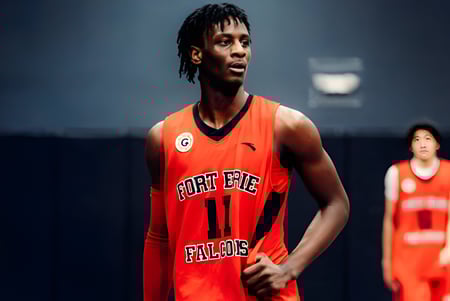 Un estudiante de la Fort Erie International Academy está en una camiseta de baloncesto roja en la cancha de baloncesto.