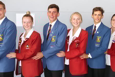 Un grupo de estudiantes del Francis Douglas Memorial College posan con ropa de graduación en un estudio.