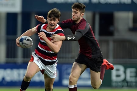 Dos jugadores de rugby en el Franciscan College Gormanston luchan en el campo por la posesión del balón.