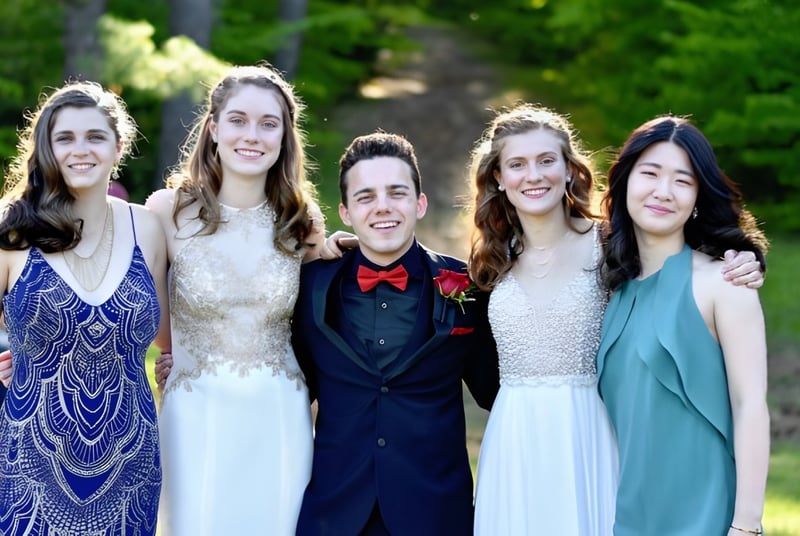 Un grupo de cinco estudiantes posan juntos en un área verde al aire libre en el campus de la Fryeburg Academy.