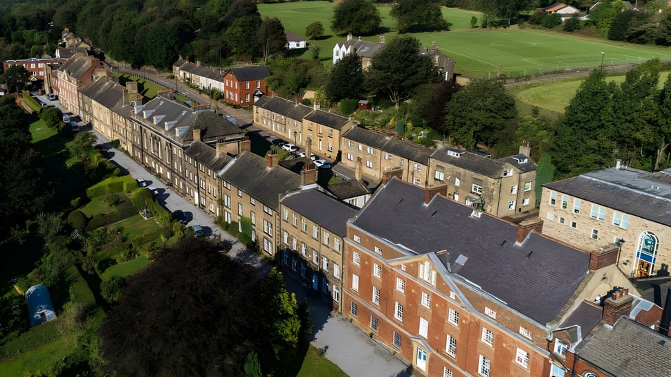 Un paisaje pintoresco con edificios históricos de ladrillo y un campanario cerca de la Fulneck School.