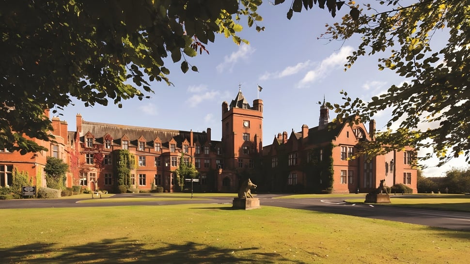 El histórico edificio principal de la Fyling Hall School se encuentra en un patio verde bajo un cielo azul.