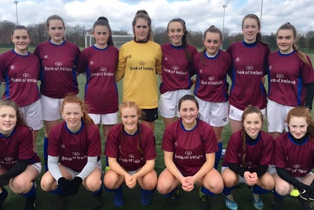 Un grupo de jugadoras de fútbol posan con los colores del club en el campo del Galway Community College.