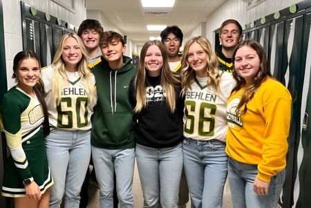 Un grupo de estudiantes está reunido en el pasillo de la Gehlen Catholic School vestidos con ropa deportiva.