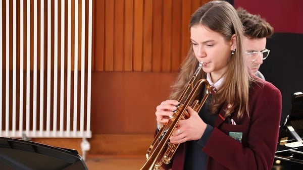 Una estudiante de George Watson’s College toca el trombón en una sala con paredes de madera.