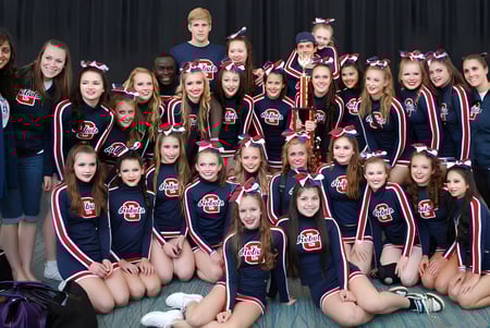 Un grupo de jóvenes deportistas posan como equipo de animadoras en el campus de Georgetown District High School.