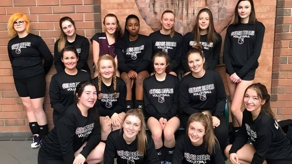 Un grupo de estudiantes femeninas posan frente a una pared de ladrillo en el terreno de la Georgian Bay District Secondary School.