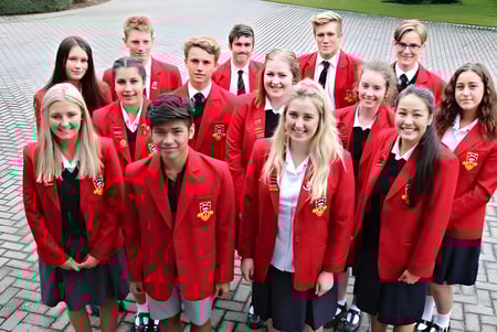 Un grupo de estudiantes de la Geraldine High School está en un camino pavimentado rodeado de áreas verdes.