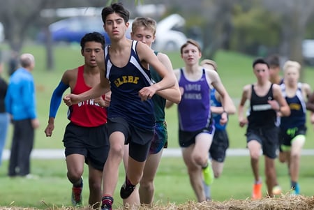 Un grupo de estudiantes del Glebe Collegiate Institute corre en una competencia en un campo de hierba.