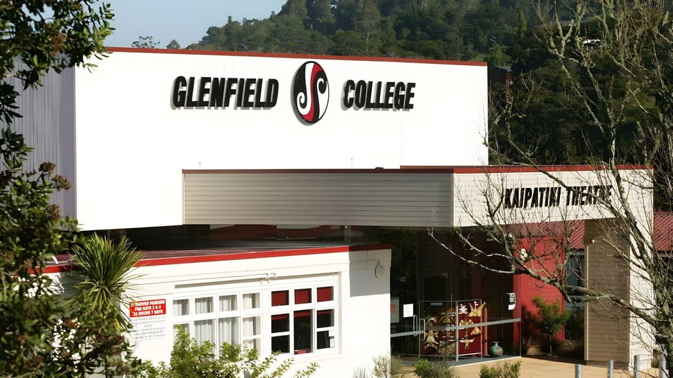 El edificio del Glenfield College con un gran letrero de la empresa está rodeado de árboles y otros edificios.