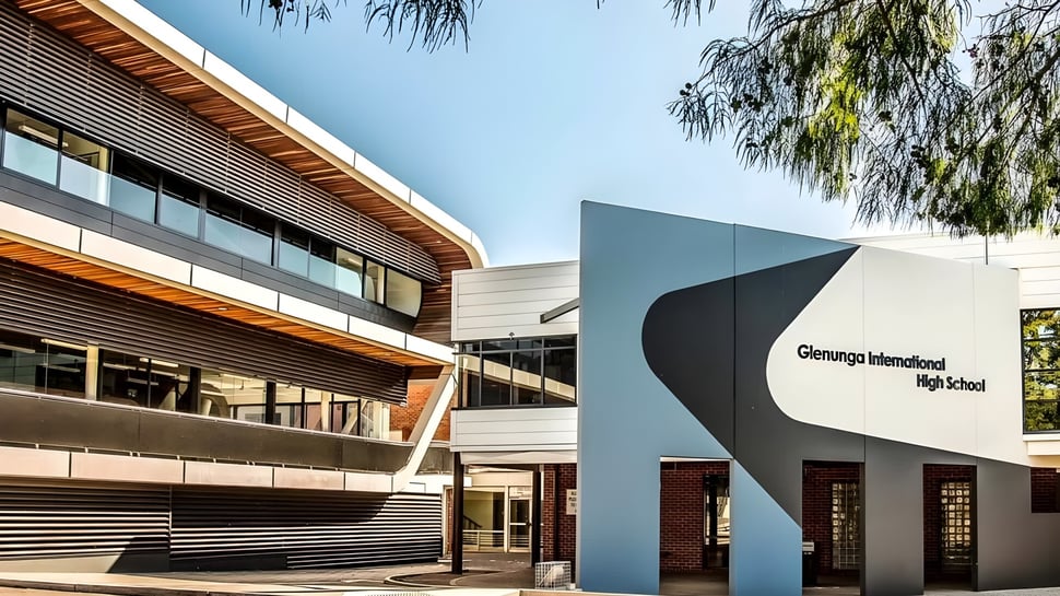 El moderno edificio escolar de la Glenunga International High School está rodeado de vegetación verde.