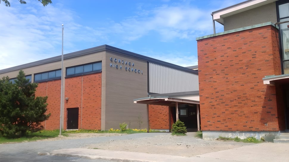 El moderno edificio de ladrillo de la Gonzaga High School con una gran entrada y áreas verdes delante.