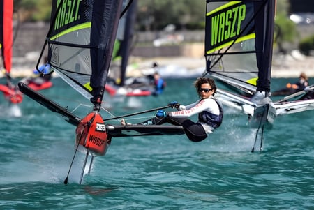 Una estudiante de la Green Bay High School navega en un pequeño velero sobre un cuerpo de agua.